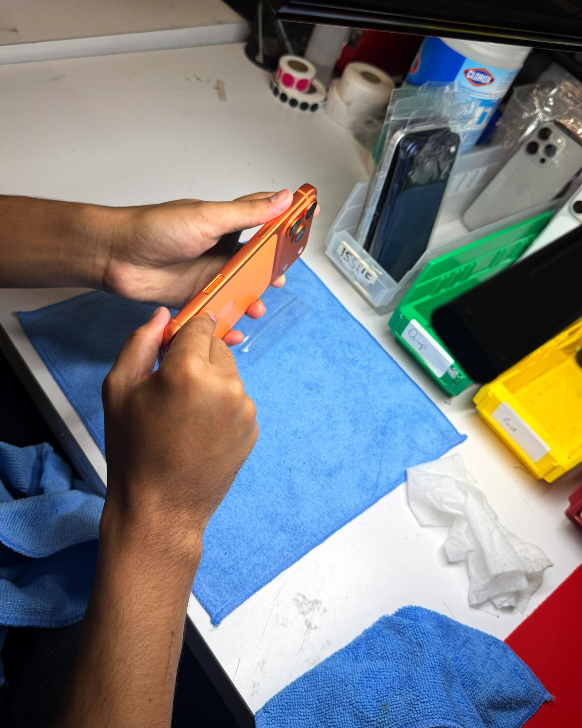 Technician inspecting a phone's cosmetic condition at the grading bench